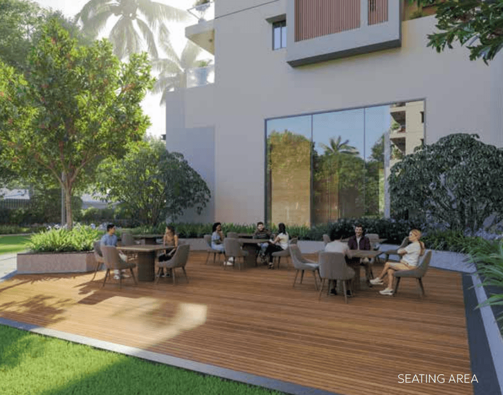 tabled seating area with chairs on wooden deck beside building in supadha gamya